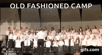 a choir is singing on a stage with a conductor .