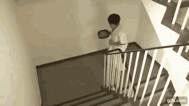a man is standing on a set of stairs holding a plate .