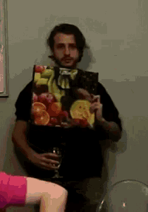 a man holding a bag of fruit and a glass
