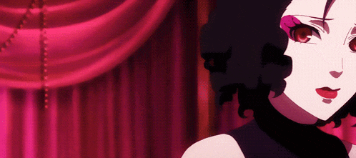 a close up of a woman 's face with a red curtain in the background