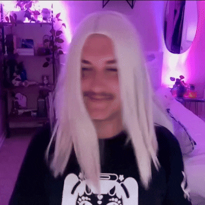 a man with white hair and a mustache is wearing a wig .