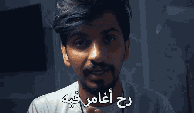 a man with a beard has arabic writing on his shirt