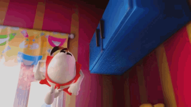 a stuffed animal is hanging from a blue cabinet in a room