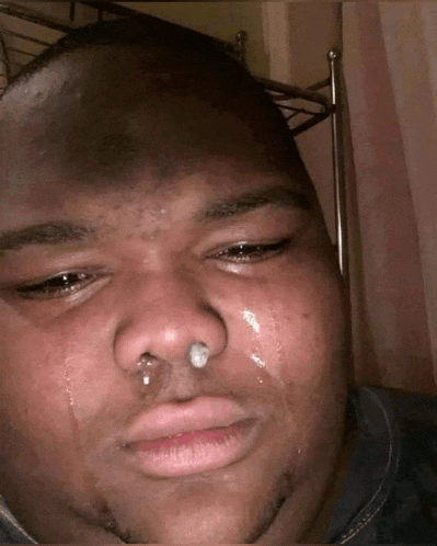 a man with a nose ring is crying with tears coming out of his nose