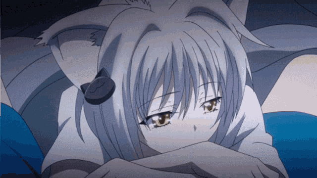 a girl with cat ears is laying down with her head on her arms