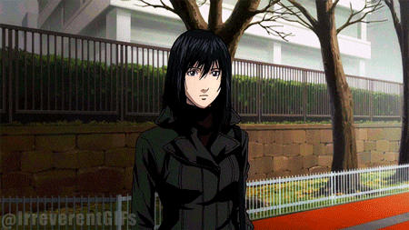 a woman in a black coat is standing in front of a fence and a tree
