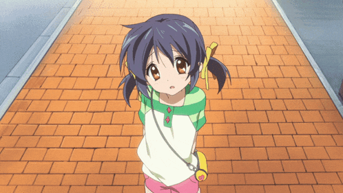 a little girl is standing on a brick sidewalk looking up