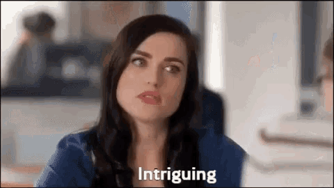a woman is making a funny face and the word intriguing is written on the screen .