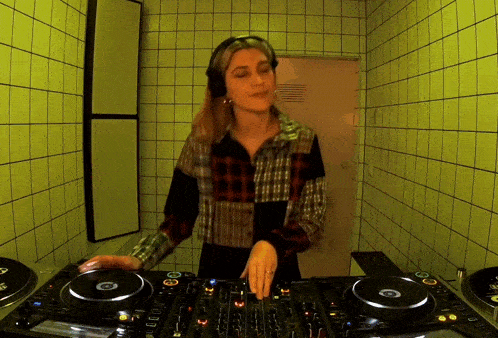 a woman wearing headphones is playing music on a pioneer mixer