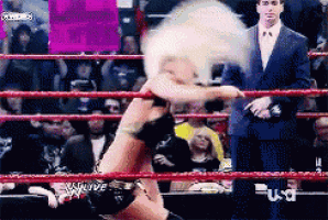 a woman in a wrestling ring is holding a sign that says ' i love you '