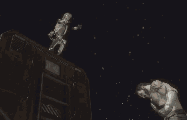 a man is laying on top of another man in a video game while wearing a glove .