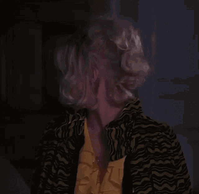 a woman smoking a cigarette in a yellow shirt