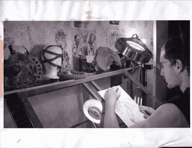 a black and white photo of a man drawing a picture