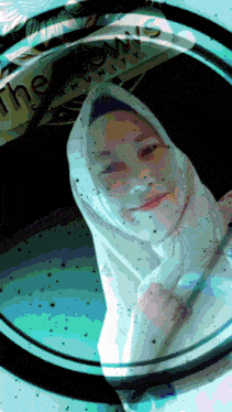 a woman in a white hijab is looking through a magnifying glass with the words the lows community on it