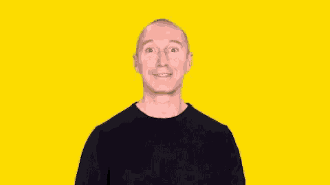 a bald man in a black shirt is making a surprised face .