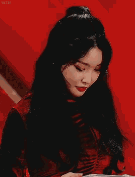 a woman with long black hair is wearing red lipstick