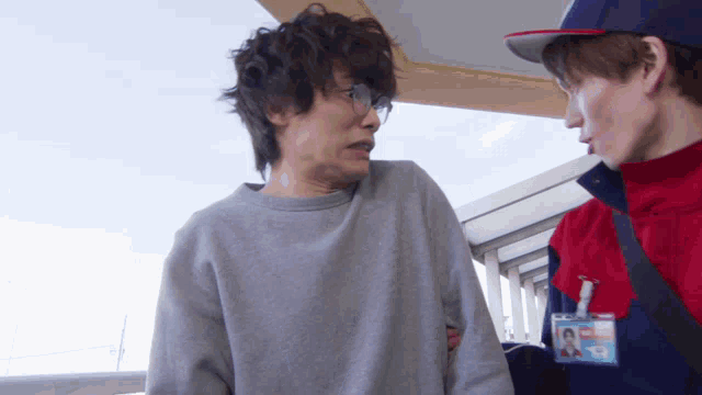 a man wearing a badge that says ' ambulance ' on it is talking to another man