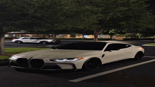 a white car is parked in a parking lot with a police car in the background