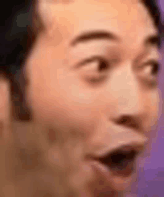 a close up of a man 's face with a surprised expression .