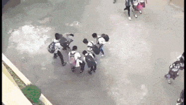 a group of students are standing in a circle on the ground .