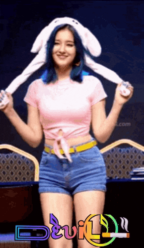 a woman wearing bunny ears and shorts with the word devil on the bottom right