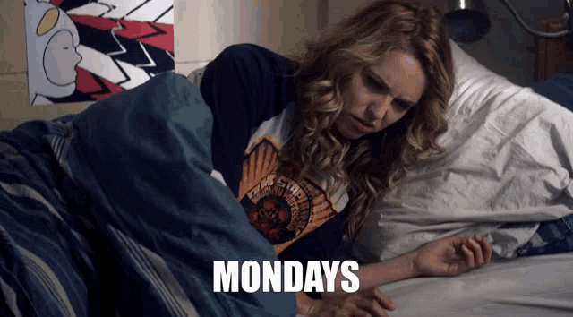 a woman is laying in bed with the word mondays written on the bottom