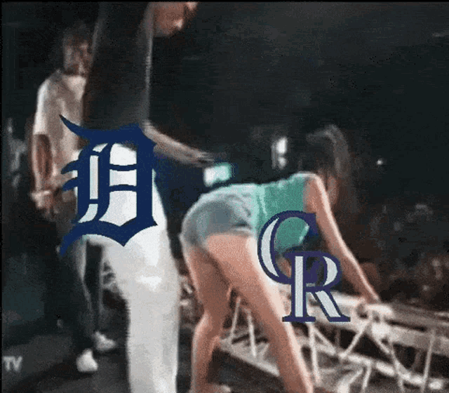 a man standing next to a woman with a detroit logo on her butt
