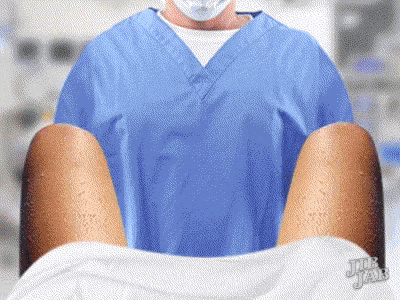 a man in a blue scrub is holding a woman 's legs in a hospital room ..