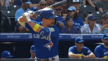 a blue jays baseball player swings his bat at a pitch