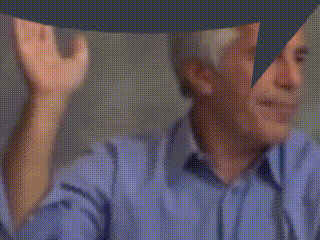 a blurry picture of a man in a blue shirt with his hands up