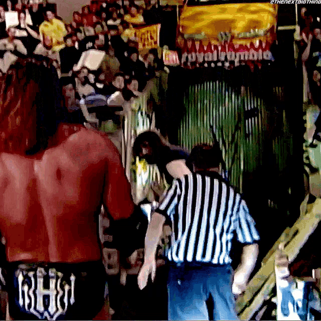 a referee stands in front of a crowd with a sign that says royal rumble