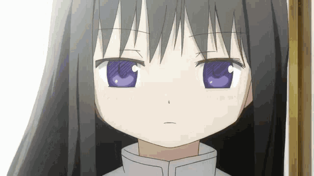 a girl with long black hair and blue eyes looks at the camera