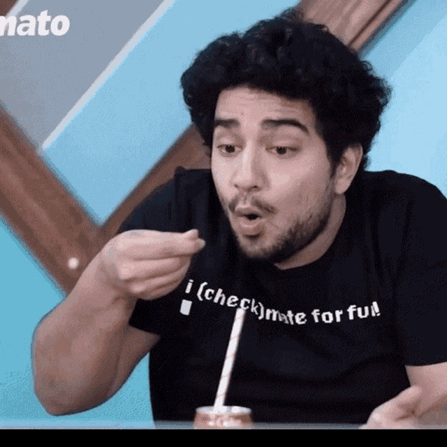 a man wearing a black shirt that says checkmate for fun