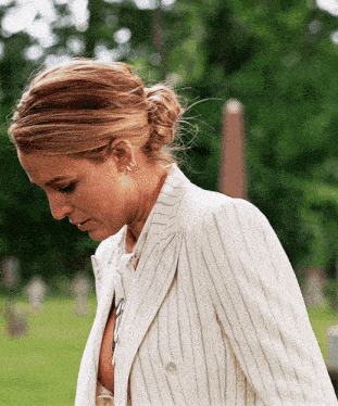 a woman in a white striped suit looks down at something