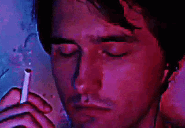 a man is smoking a cigarette with his eyes closed in a pixelated image .
