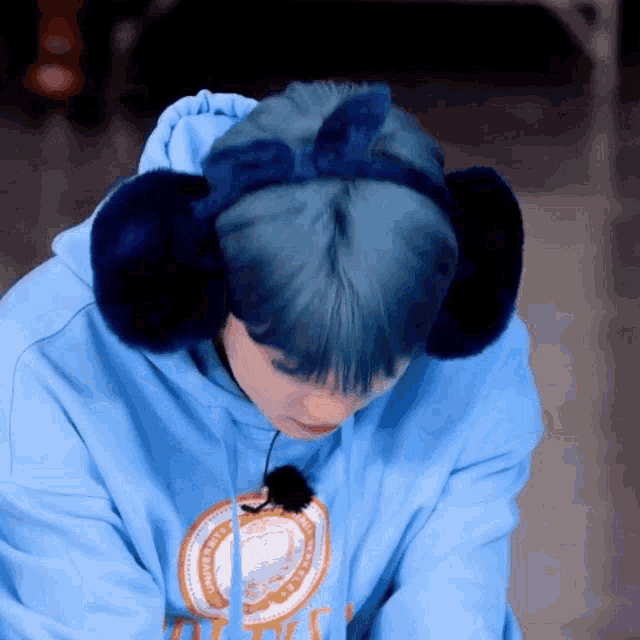 a person wearing a blue hoodie and ear warmers