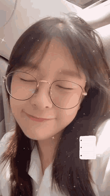 a girl wearing glasses with her eyes closed