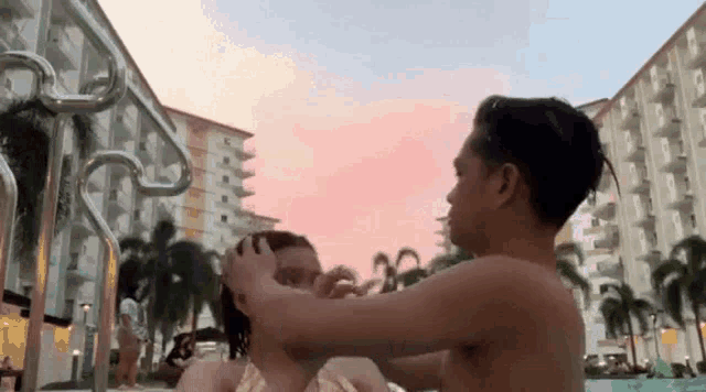 a man is touching a woman 's hair in a pool .
