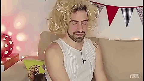 a man with a beard wearing a wig is sitting on a couch .