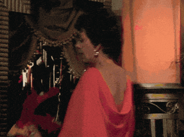 a woman in a red dress stands in front of a row of keys