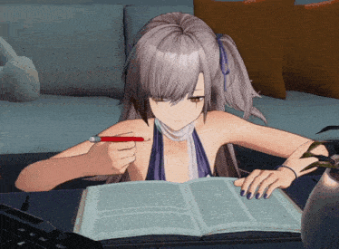 a girl is sitting at a table holding a pen and reading a book
