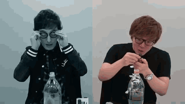 a man wearing glasses is holding a bottle and another man is holding a bottle with a straw