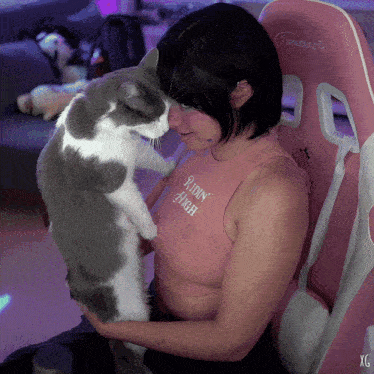 a woman wearing a pink shirt that says " robin high " holds a cat