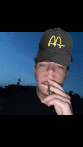 a man is wearing a mcdonald 's hat and smoking a cigar