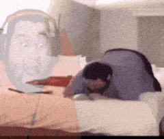 a man wearing headphones is laying on a bed with a knife in his hand