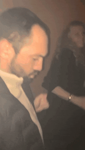 a man in a suit is standing next to a woman