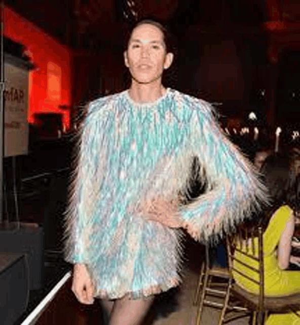 a woman in a furry dress is standing in front of a crowd .