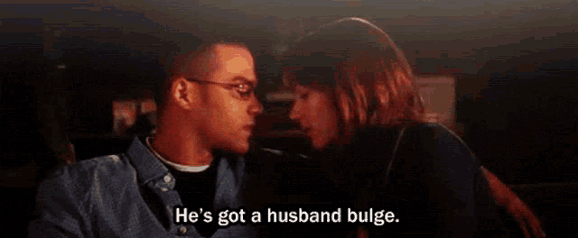 a man and woman are kissing in a car and the man says he 's got a husband bulge