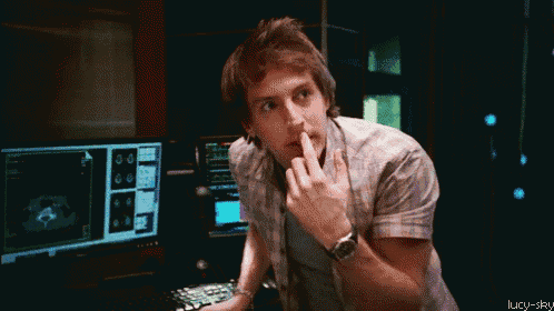 a man sitting in front of a computer making a funny face