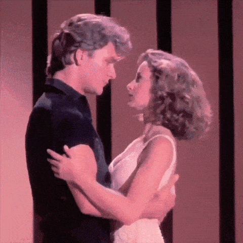 a man and a woman are dancing together in front of a pink background .